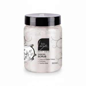 A 500ml bottle of BioLuxe Diamond Scrub. The bottle has a white label with the BioLuxe logo and the product name in black text. The scrub itself is a light beige color.