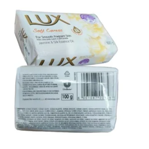 A rectangular bar of LUX Soapsoft Caress soap with a light pink color and a jasmine flower design on the label