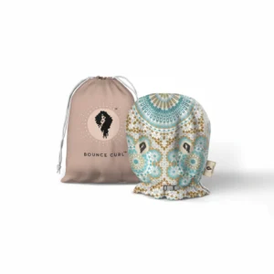 A soft, adjustable hair bonnet in a neutral color. The bonnet has an elastic strap to secure it in place.