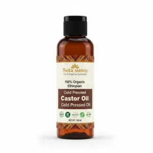 A clear glass bottle with a white label containing Seta Sunny Cold Pressed Castor Oil. The label features the brand name, product name, and a green leaf icon.