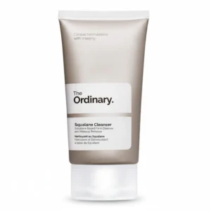 A clear glass bottle with a white label featuring the brand name 'The Ordinary' and the product name 'Squalane Cleanser'. The bottle contains a clear, light-colored liquid cleanser.