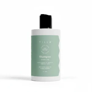 A bottle of Tilla Hair Shampoo with a white label and green accents. The bottle has a pump dispenser and contains 300ml of product.