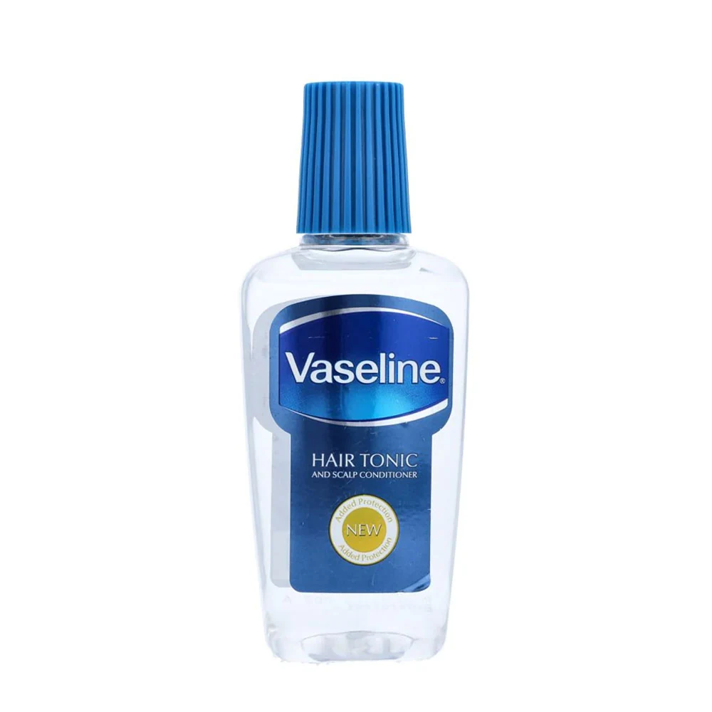 A clear glass bottle with a white label and cap, containing a golden-colored hair oil. The Vaseline logo is prominently displayed on the label.