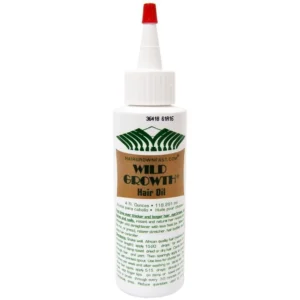 A bottle of Wild Growth Hair Oil with a label showing the product name and size (118 ml)