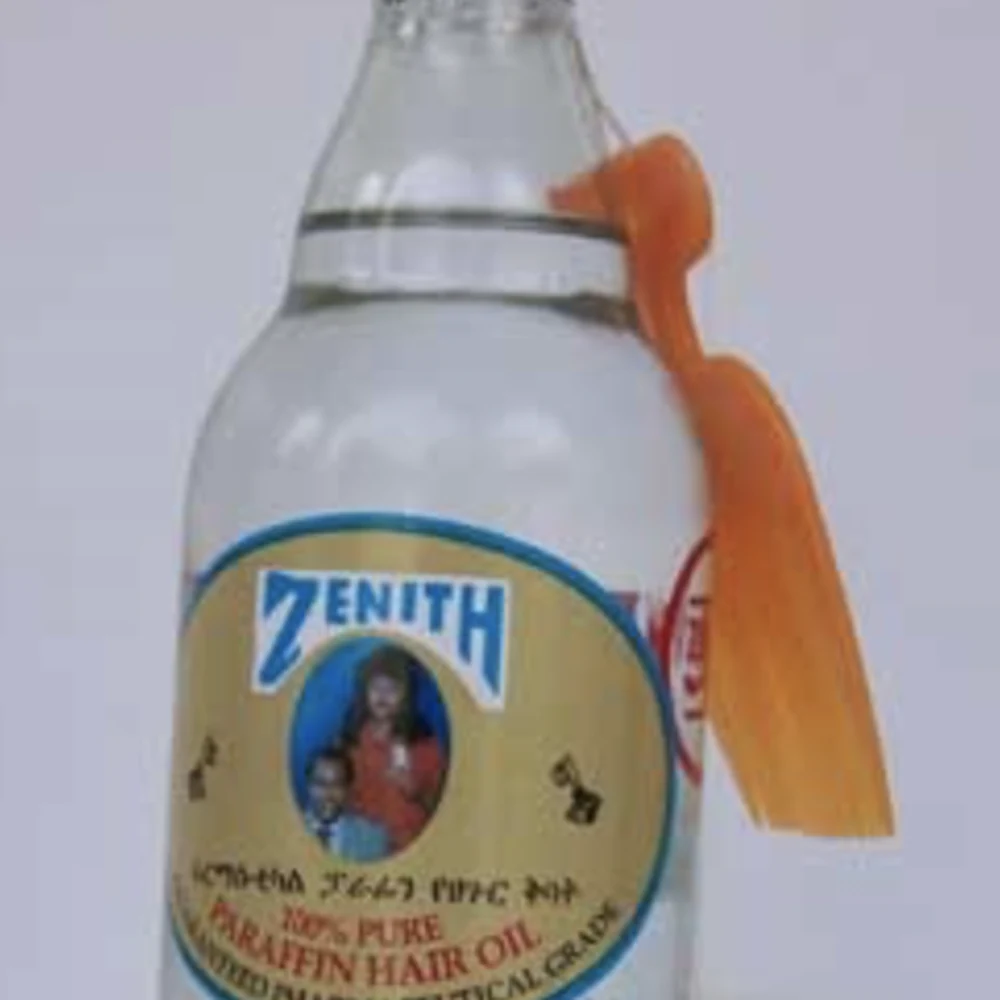 A bottle of Zenith Parafin Hair Oil with a white label and cap. The bottle is made of clear glass and contains a golden-colored hair oil.