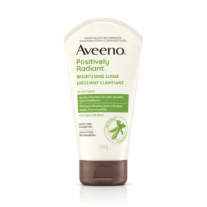 A white and green tube of Aveeno Positively Radiant Skin Brightening Daily Scrub. The label features the Aveeno logo and product name.