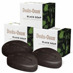 A round black bar of Dudu Osun African Black Soap with a green leaf design on the label