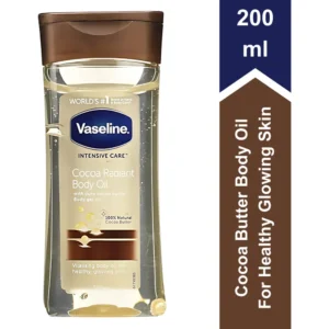 A bottle of Vaseline Cocoa Radiant Body Oil. The bottle is made of clear glass and has a white label with the Vaseline logo and the product name. The oil inside the bottle appears to be a rich, golden color.